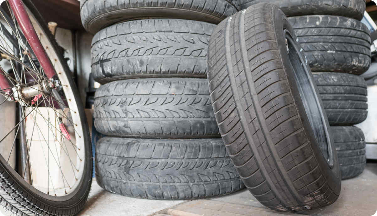 Fotografie von stehenden und liegenden Reifen in der Garage.