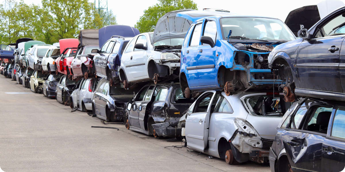 Ausgeschlachtete Autos stehen gestapelt auf dem Verwertungshof.