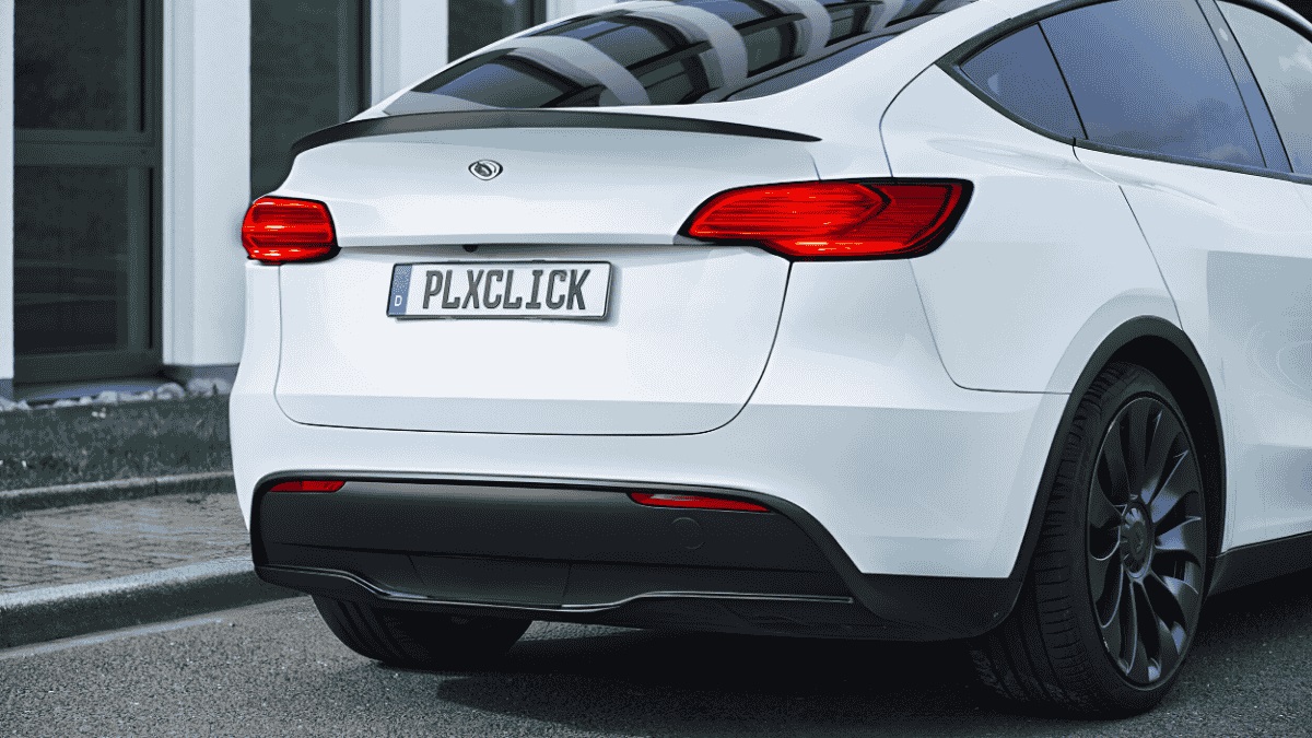 Heck eines weißen modernen Autos mit dem Schriftzug PLXCLICK auf dem Kennzeichen, das von einem nahezu unsichtbaren Kennzeichenhalter gehalten wird.