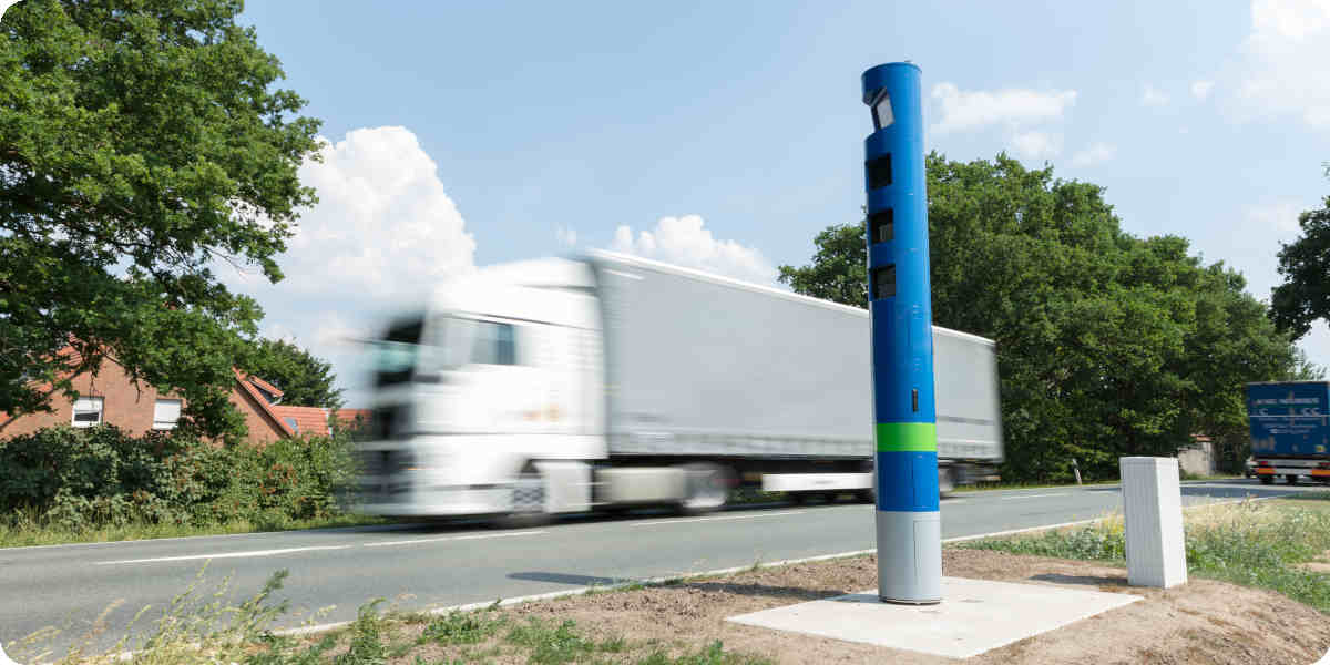 Blaue Mautsäule steht am Straßenrand und scannt einen LKW.