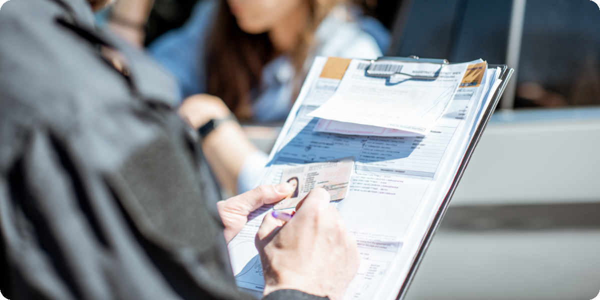 Ein Polizist schreibt die persönlichen Daten vom Personalausweis während einer Verkehrskontrolle ab.