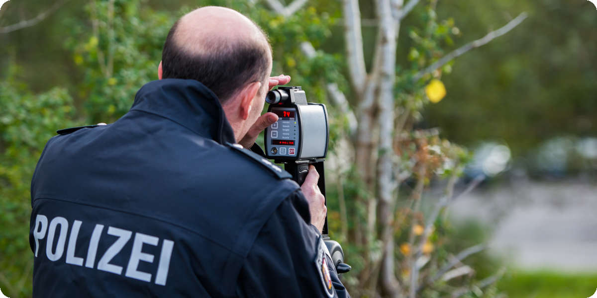 Polizist misst die Geschwindigkeit mit einer Radarfalle.