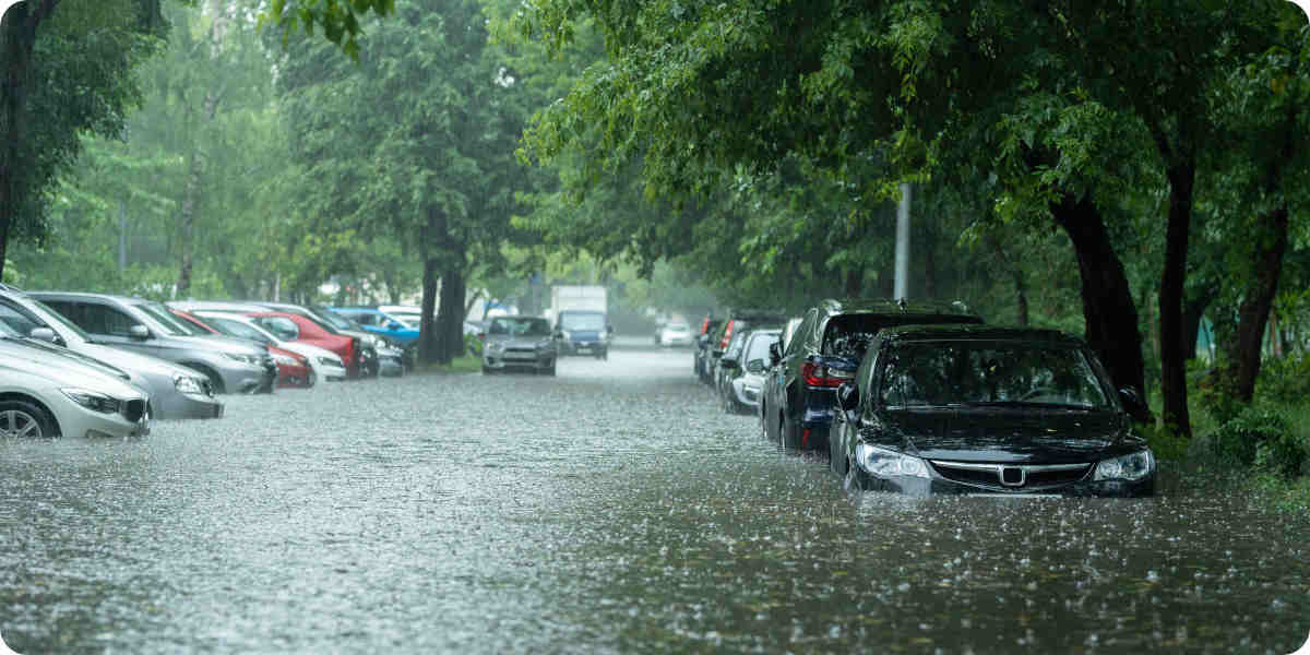 Eine überschwemmte Straße mit parkenden Autos.
