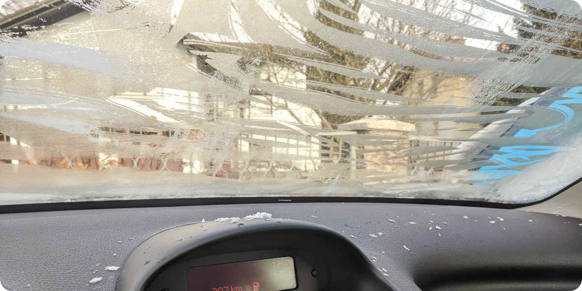 Fotografie der von innen gefrorenen Frontscheibe eines Autos.