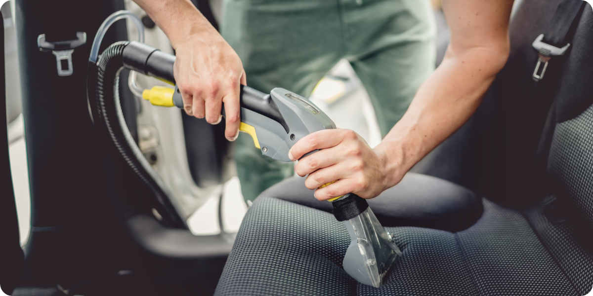 Ein Nasssauger im Einsatz auf einem Autositz.