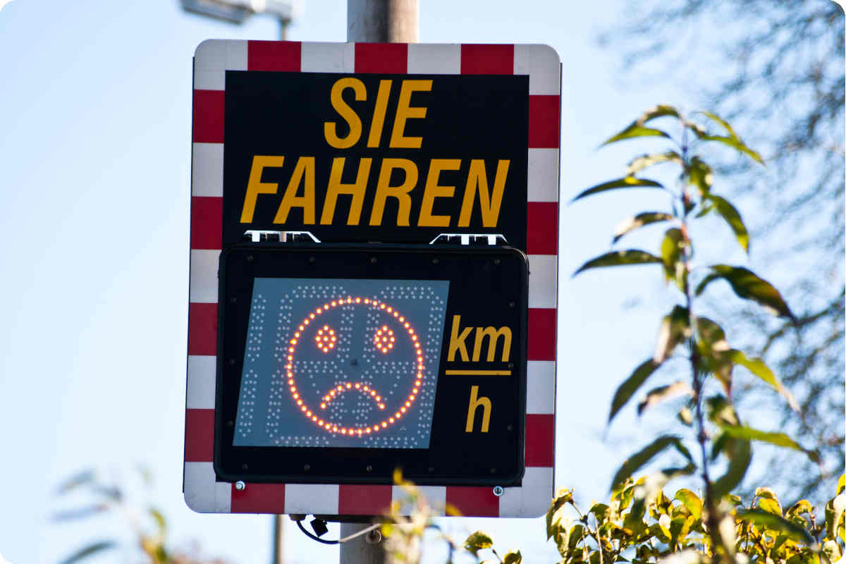 Ein Schild als Geschwindigkeitsanzeige mit Wertung als Emoji.