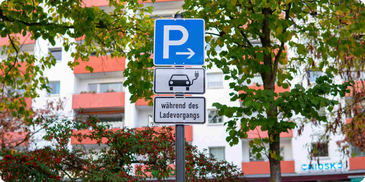 Parkschild mit Zusatzschilder für reine Elektroautos mit E-Kennzeichen und während des Ladevorgangs.