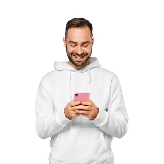 Ein junger Mann schaut auf sein Smartphone und lächelt.
