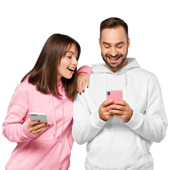 Zwei junge Personen lächeln und schauen auf Ihr Smartphone.