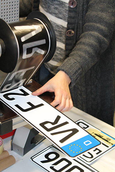 Verpackungsmaterial liegt zusammen mit Kennzeichen und Kartons auf einem Tisch.