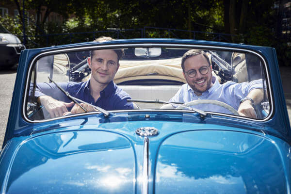 Philipp und Dr. Felix Kroschke sitzen im blauen Käfer.